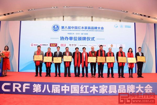 明清居董事长金彪云（左四）上台接受第八届中国红木家具品牌大会协办单位牌匾