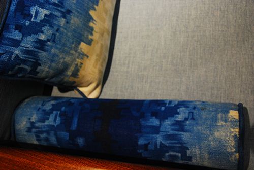 沙发的抱枕、圆枕上有蓝色的图案，像水墨画一样